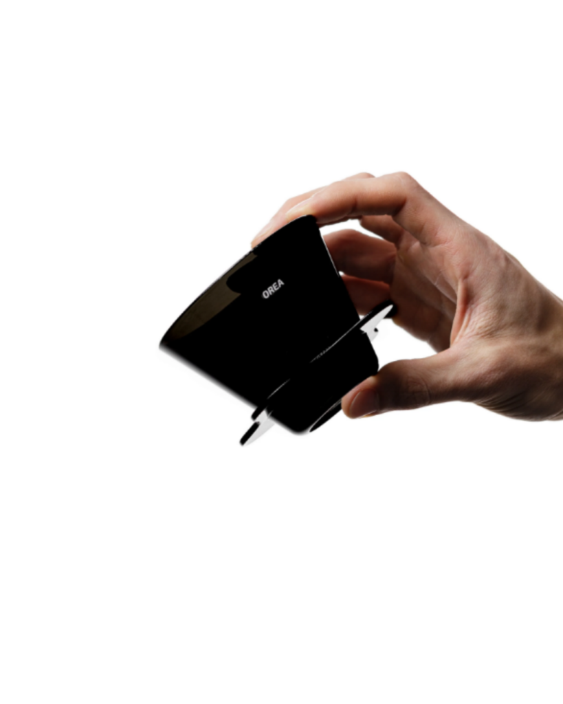 Hand holding a black Orea wall charger plug
